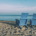 Two blue beach chairs on a sandy beach